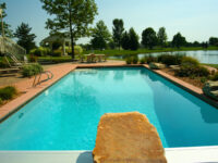 Traditional swimming pool by lake - Master Pools Guild