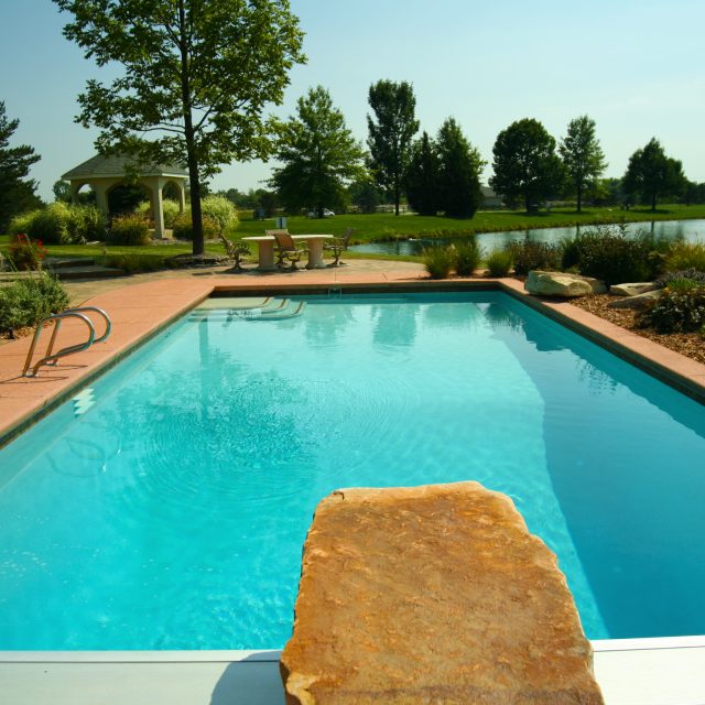 Traditional swimming pool by lake - Master Pools Guild